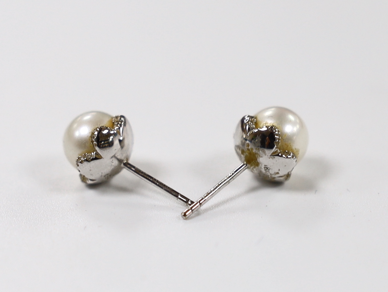 A pair of 18ct white gold, cultured pearl and diamond chip set ear studs, pearl diameter 8.15mm, gross weight 4.1 grams.